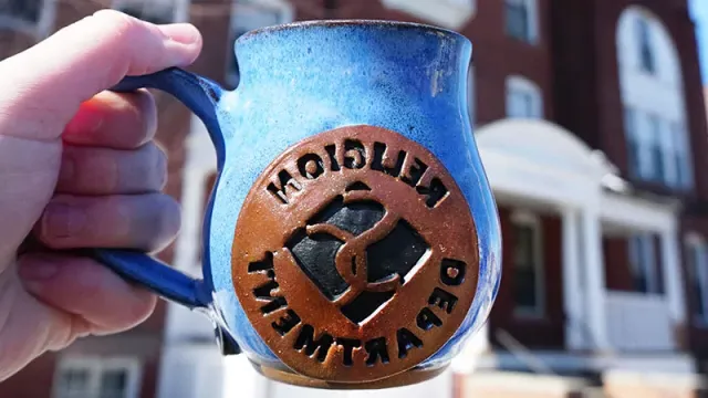 Blue pottery mug with the Smith College diamond and the words "Religion Department"